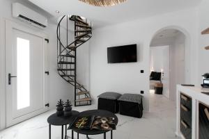 Sala de estar blanca con escalera de caracol y taburetes negros en Black Concept Maisonette, en Naxos Chora