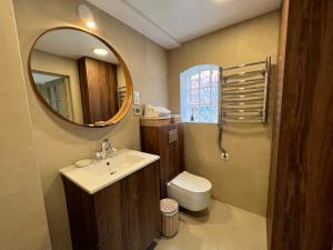 a bathroom with a sink and a toilet and a mirror at Banga & Sunrise Nida in Nida