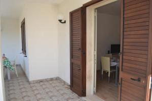 eine offene Tür zu einem Zimmer mit einem Tisch in der Unterkunft Casa ALYSSA per 6 in San Foca