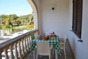 einen Tisch mit einem grünen und weißen Tischtuch auf dem Balkon in der Unterkunft Casa ALYSSA per 6 in San Foca