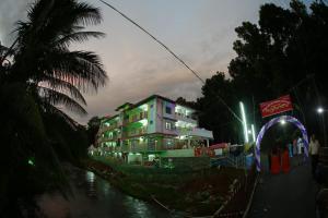 a building with lights on a river at night at Thodupuzha 4-bhk Luxury Home awy from home in Thodupuzha