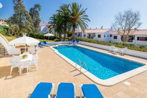 a pool with chairs and a table and a house at Villa SUN PARADISE in Son Bou