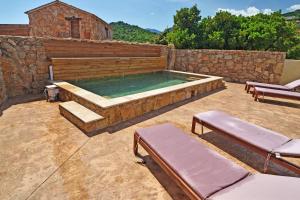 una piscina con un muro in pietra e una pietra di Bergeries de charme Caselle di Conca a Conca