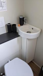 a bathroom with a white sink and a toilet at Außergewöhnlich übernachten bei Tübingen. in Ammerbuch