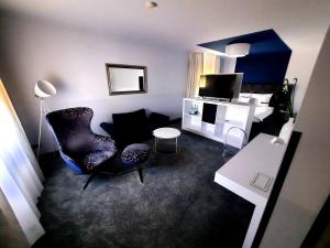 a living room with a chair and a television at Hotel Bei den Tongruben in Ravolzhausen