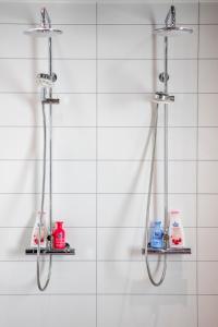 a bathroom with two shower heads and two shelves at Haaveilevi Levi in Sirkka