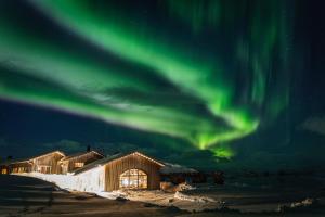 a building with the aurora in the sky at Niehku Mountain Villa in Riksgränsen