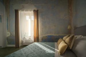 a bedroom with a bed and a window at Domu Manca in Torpè