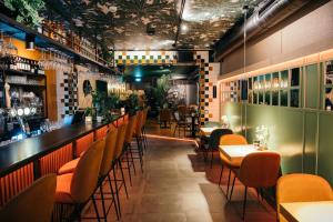 a restaurant with a bar with orange chairs and tables at Winston B&B in Eindhoven