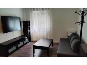 a living room with a couch and a flat screen tv at Tranquilo apartamento 5 pers. Madrid Río Mendoza in Madrid