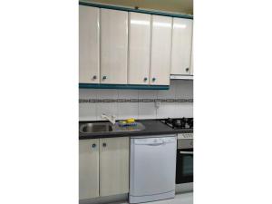a kitchen with white cabinets and a white dishwasher at Tranquilo apartamento 5 pers. Madrid Río Mendoza in Madrid