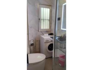 een badkamer met een toilet, een wastafel en een wasmachine bij Tranquilo apartamento 5 pers. Madrid Río Mendoza in Madrid