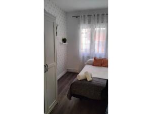 een kleine slaapkamer met een bed en een raam bij Tranquilo apartamento 5 pers. Madrid Río Mendoza in Madrid