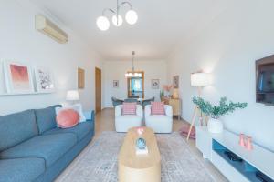 a living room with a blue couch and a table at Boavista Charming Apartment in Lagos