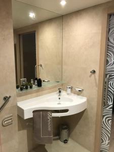 een badkamer met een witte wastafel en een spiegel bij Chambéry Appart'S in Chambéry