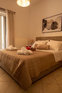 - une chambre avec un grand lit et des serviettes dans l'établissement Agathi's house, à Mitikas
