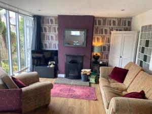 a living room with two couches and a fireplace at No.1 The Coach House in Silverdale