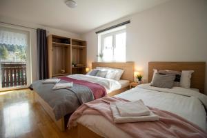 Apartments Pod Bregom في كراجسكا غورا: غرفة نوم بها سريرين ونافذة