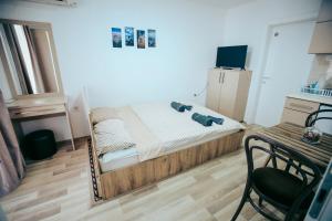 ein kleines Schlafzimmer mit einem Bett und einem Tisch mit einem Stuhl in der Unterkunft madox in Ohrid