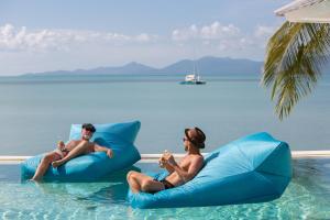 dos personas sentadas sobre inflables en el agua en Tembo Beach Club & Resort en Koh Samui