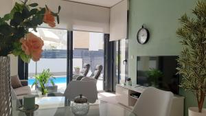a living room with a glass table and white chairs at Villa Wilhelmina in Torrevieja