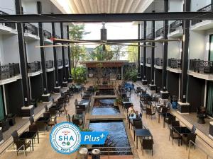 a restaurant with a pool in the middle of a building at Namthong Nan Hotel in Nan