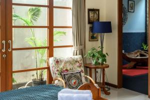 a bedroom with a bed and a chair and a window at Sonti Villa in Seminyak