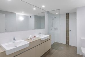 a bathroom with a sink, mirror, and bathtub at Ramada Resort by Wyndham Port Douglas in Port Douglas