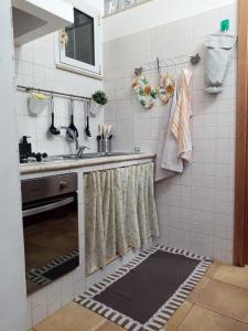 una cucina con lavandino e tenda per la doccia di Casa Santa Chiara a Mola di Bari