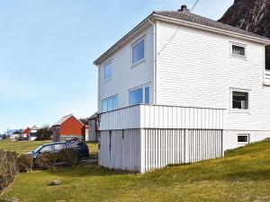 uma casa branca com um carro estacionado ao lado em Holiday home Leinøy em Fosnavåg