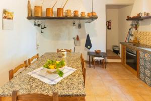 マナコルにあるMurtera- Traditional country manor house for 9 people 5 bedrooms and 4 bathrooms near Sant Llorençのキッチン(テーブル、フルーツボウル付)