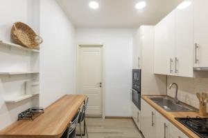 eine Küche mit weißen Schränken und einer hölzernen Arbeitsplatte in der Unterkunft Best Location Apartment in Old Tbilisi in Tbilisi City