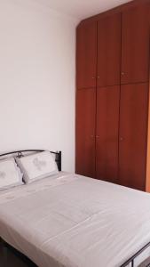 ein Schlafzimmer mit einem großen Bett und einem Holzschrank in der Unterkunft central apartments Eretria in Eretria