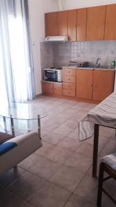 een keuken met een glazen tafel in een kamer bij central apartments Eretria in Eretria