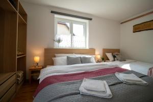 Apartments Pod Bregom في كراجسكا غورا: غرفة نوم بها سريرين ونافذة