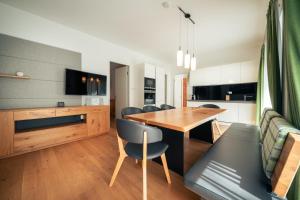 cocina y comedor con mesa de madera y sillas en Appartement Hoam by Schladming Appartements, en Schladming