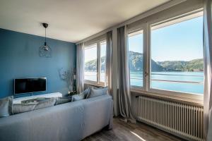 a living room with a couch and a large window at La Finestra Blu by Quokka 360 - with a panoramic lake view in Ponte Tresa