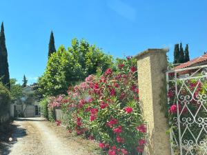 a garden with pink flowers on a fence at Clos Des Plages Maison De Vacances in La Ciotat