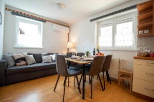 Apartments Pod Bregom في كراجسكا غورا: غرفة معيشة مع طاولة وكراسي وأريكة