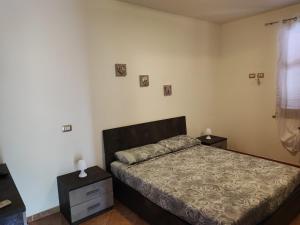 een slaapkamer met een bed met twee nachtkastjes en twee lampen bij CASA VACANZE DA NONNA MELA in Alghero