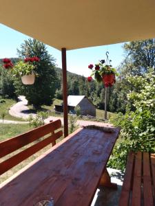 una mesa de madera sentada en un porche con flores. en Casa din Poiană, en Hănăşeşti