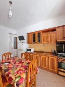 cocina con armarios de madera y mesa con mantel en Apartment Celaj Velipoje, en Velipojë