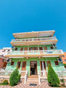 un edificio verde con balcones blancos. en Apartment Celaj Velipoje, en Velipojë