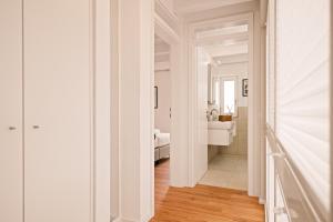 a white hallway with a bedroom and a bathroom at Ferien-Wohlfühlapartment Seekretzer - mit priv Strandzugang in Friedrichshafen