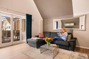 a woman sitting on a couch in a living room at Wohlfühlloft Seekretzer mit privatem Seezugang in Friedrichshafen