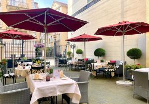 a patio with tables and chairs and umbrellas at Hotel Der Kleine Prinz in Baden-Baden