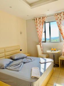 a bedroom with a bed and a table and a window at HOTEL SARDA in Vau i Dejës