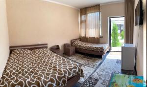 1 dormitorio con 1 cama y TV en Guest House Janel, en Cholpon-Ata