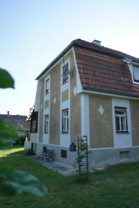 budynek z czerwonym dachem i ławką przed nim w obiekcie Landhaus im Hartbergerland w mieście Hartberg