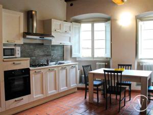 a kitchen with a table and a table and chairs at Via Ruga degli Orlandi - Valente Italian Properties in Pescia